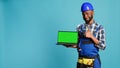 Happy mechanic pointing at laptop with greenscreen Royalty Free Stock Photo