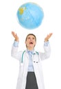 Happy medical doctor woman throws up globe