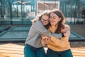 Close up photo of laughing happy woman friends hugging each other on city street Royalty Free Stock Photo