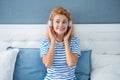 Happy melomaniac girl listening to music on bed, music. Relaxing girl enjoying music Royalty Free Stock Photo