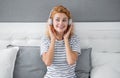 Happy melomaniac girl listening to music on bed, music. Relaxing girl enjoying music Royalty Free Stock Photo