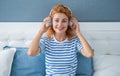 Happy melomaniac woman listening to music on bed, music. Relaxing woman enjoying music Royalty Free Stock Photo