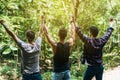 Happy men traveler friends hands raise up together at nature,Enjoying backpacking concept,Back view