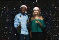 Joyful couple congratulating on christmas with champagne at black background