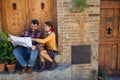 Man and woman traveling and reading map in city of location