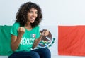 Happy mexican female soccer fan with flag of Mexico watching game on tv Royalty Free Stock Photo