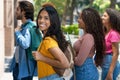 Happy mexican female student with group of latin american and caucasian and african american young adults Royalty Free Stock Photo