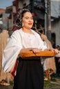 Happy Mexican woman with traditional customs holding sweet basket during the annual dancing parade