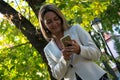 Smiling businesswoman text messaging on cell phone in nature. Royalty Free Stock Photo