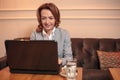 Mid adult business woman sitting in a cafe and working on a laptop Royalty Free Stock Photo