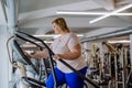 Happy mid adult overweight woman exercising on stepper indoors in gym Royalty Free Stock Photo