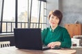 Happy mid adult woman working laptop computer indoors Royalty Free Stock Photo