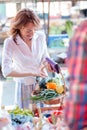 Mid adult woman buying fresh organic vegetables on a farmer`s market Royalty Free Stock Photo