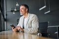 Happy mid age business man using mobile cell phone working in modern office. Royalty Free Stock Photo