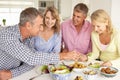 Happy Mid age couples enjoying meal at home Royalty Free Stock Photo