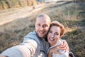 Happy middle age couple make selfie outdoors.