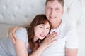 Happy middle age family couple in bed. White interior. Love and healthy relationships. Husband and wife portrait