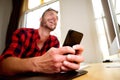 Happy middle age man holding cellphone and laughing Royalty Free Stock Photo