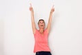 Happy middle age woman laughing with arms raised and pointing fingers up Royalty Free Stock Photo