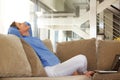 Happy middle age woman sitting on sofa with laptop Royalty Free Stock Photo