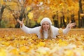 Happy middle age woman throwing yellow autumn leaves