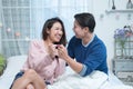 Happy middle aged Asian couple be excited, looking result at pregnancy test together on bed at home. Wife surprise husband with Royalty Free Stock Photo