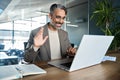 Happy middle aged business man having virtual meeting hybrid working in office. Royalty Free Stock Photo