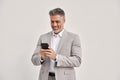 Happy middle aged business man wearing suit using phone looking at smartphone. Royalty Free Stock Photo