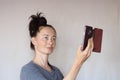 Happy middle aged casual woman taking selfie with the smartphone social active and smiling at the camera on grey wall Royalty Free Stock Photo