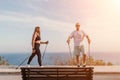 Happy Middle aged couple or friends practicing nordic walking in park near sea. Mature couple with trekking poles Royalty Free Stock Photo