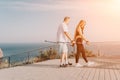 Happy Middle aged couple or friends practicing nordic walking in park near sea. Mature couple with trekking poles Royalty Free Stock Photo