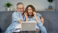 A happy middle-aged couple, looking at a laptop, feels like an online winner. Royalty Free Stock Photo