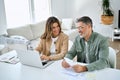 Happy middle aged couple calculating financial expenses using laptop at home. Royalty Free Stock Photo