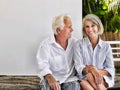 Happy middle aged couple sitting on verandah