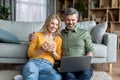 Happy Middle Aged Couple Spending Time With Laptop At Home Royalty Free Stock Photo