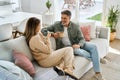 Happy middle aged couple talking drinking coffee relaxing on couch at home. Royalty Free Stock Photo