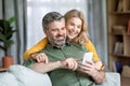 Happy Middle Aged Couple Using Mobile Phone At Home Together Royalty Free Stock Photo