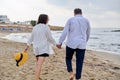 Happy middle aged couple walking together on the beach, back view Royalty Free Stock Photo