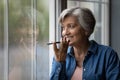 Happy middle aged elderly woman recording audio message. Royalty Free Stock Photo