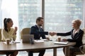 Happy middle-aged executive handshaking new male partner at team meeting Royalty Free Stock Photo