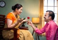 Happy middle aged man proposing his wife by giving red rose at home - concept of wedding anniversary, affection and love Royalty Free Stock Photo