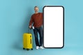 Happy middle aged man traveller using huge smatphone, mockup