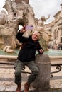 happy middle aged man on vacation taking a selfie in front of the fountain in piazza navona in rome Royalty Free Stock Photo