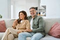 Happy middle aged mature romantic couple hugging sitting on couch at home. Royalty Free Stock Photo