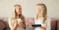 Happy middle aged mother and adult daughter, women talking looking at each other together at home Royalty Free Stock Photo