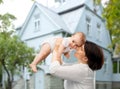 Happy middle-aged mother with baby over house Royalty Free Stock Photo