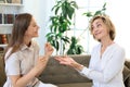 Happy middle aged mother and daughter talking on sofa in living room Royalty Free Stock Photo