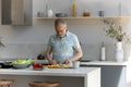 Happy middle aged senior man cooking in kitchen. Royalty Free Stock Photo