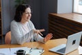 Happy mature blonde lady sitting on couch, holding video call with friends, head shot close up portrait. Web cam view Royalty Free Stock Photo