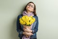 Happy middle aged woman with bouquet of yellow flowers, green wall background Royalty Free Stock Photo